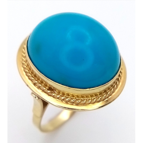 163 - An 18K Yellow Gold (tests as) Turquoise Ring. A large pale blue turquoise cabochon in a decorative s... 
