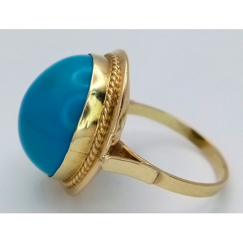 163 - An 18K Yellow Gold (tests as) Turquoise Ring. A large pale blue turquoise cabochon in a decorative s... 