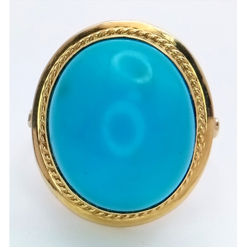 163 - An 18K Yellow Gold (tests as) Turquoise Ring. A large pale blue turquoise cabochon in a decorative s... 