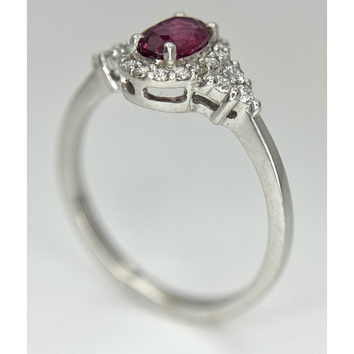 177 - An 18K White Gold, Ruby and Diamond Ring. 0.25ct oval cut high grade central ruby with a diamond clu... 