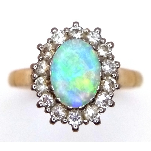 65 - An 18K Yellow Gold Opal and Diamond Ring. A 1ct central opal with a 0.52ctw diamond surround. Size N... 