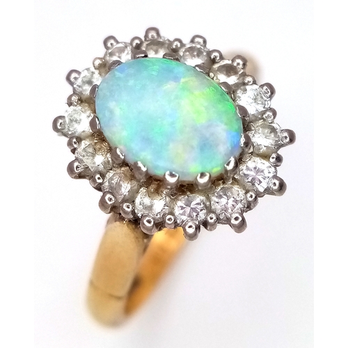 65 - An 18K Yellow Gold Opal and Diamond Ring. A 1ct central opal with a 0.52ctw diamond surround. Size N... 