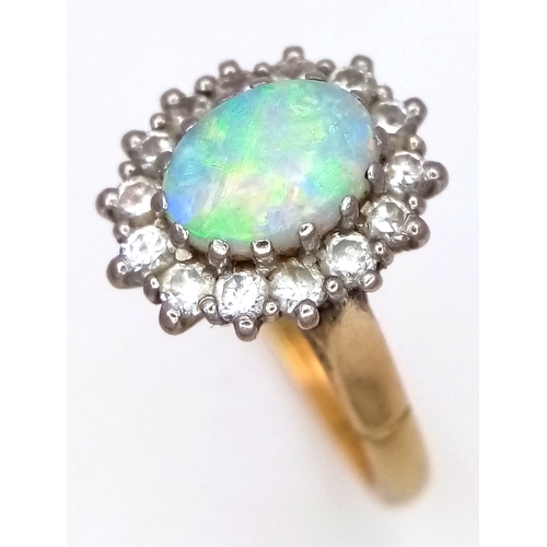 65 - An 18K Yellow Gold Opal and Diamond Ring. A 1ct central opal with a 0.52ctw diamond surround. Size N... 