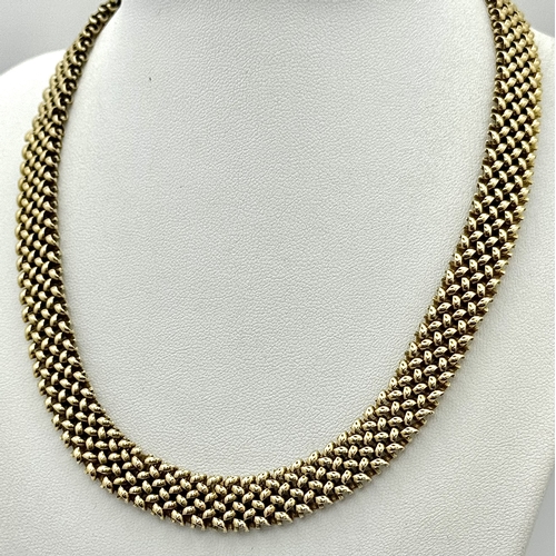 87 - A Glamourous Vintage 9K Yellow Gold Necklace and Bracelet Set. Intricate curved links create a stunn... 