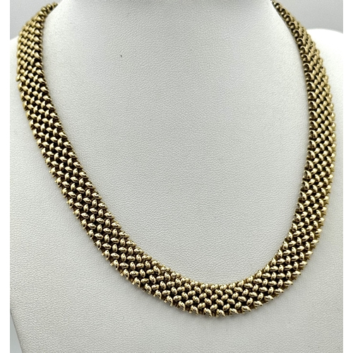 87 - A Glamourous Vintage 9K Yellow Gold Necklace and Bracelet Set. Intricate curved links create a stunn... 