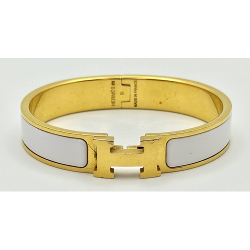 118 - An Hermes Gilded and White Enamel Bangle. 12mm width. Ref: STK024264