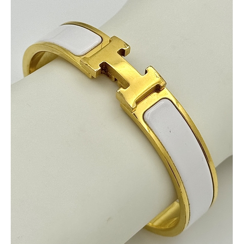 118 - An Hermes Gilded and White Enamel Bangle. 12mm width. Ref: STK024264