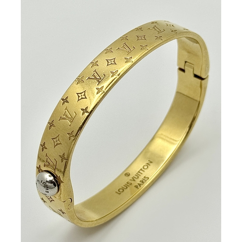 139 - A Louis Vuitton Gilded Bangle. Monogram decoration. 10mm width. Ref: STK024155