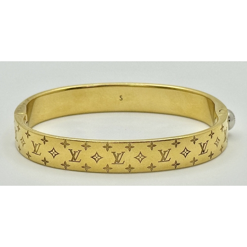 139 - A Louis Vuitton Gilded Bangle. Monogram decoration. 10mm width. Ref: STK024155