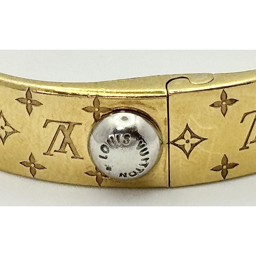 139 - A Louis Vuitton Gilded Bangle. Monogram decoration. 10mm width. Ref: STK024155