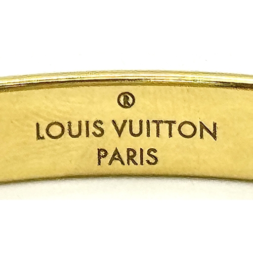139 - A Louis Vuitton Gilded Bangle. Monogram decoration. 10mm width. Ref: STK024155