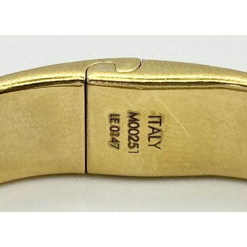 139 - A Louis Vuitton Gilded Bangle. Monogram decoration. 10mm width. Ref: STK024155