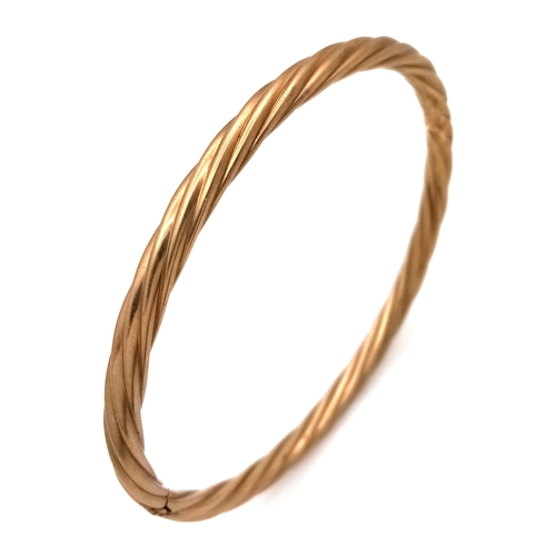162 - A 9K Yellow Gold Clip Open Bangle. Twist form. 6mm width. 58mm inner diameter. 8.6g.