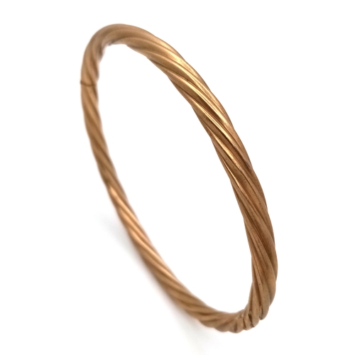 162 - A 9K Yellow Gold Clip Open Bangle. Twist form. 6mm width. 58mm inner diameter. 8.6g.
