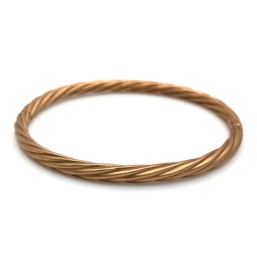 162 - A 9K Yellow Gold Clip Open Bangle. Twist form. 6mm width. 58mm inner diameter. 8.6g.
