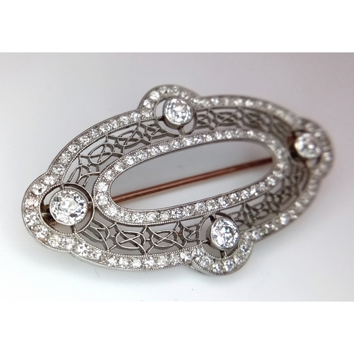 121 - An Art Deco Platinum and Diamond Encrusted Brooch. Four Old European cut diamonds - 0.60ctw with a t... 
