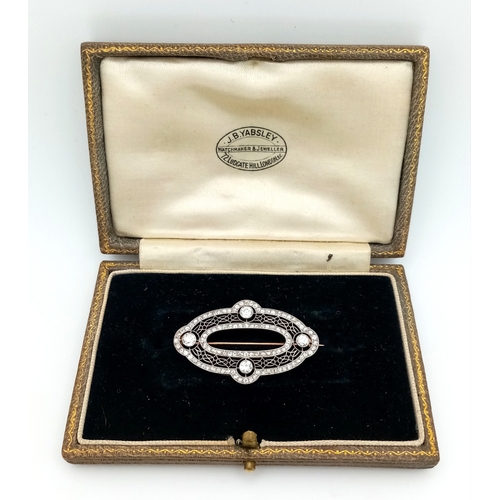 121 - An Art Deco Platinum and Diamond Encrusted Brooch. Four Old European cut diamonds - 0.60ctw with a t... 
