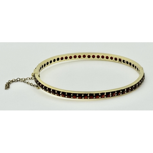 752 - A stunning gold plated silver full Garnet stone set click-on bangle (include safety chain). Total we... 