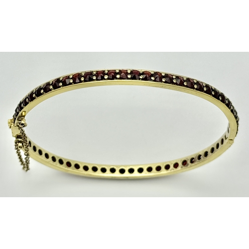 752 - A stunning gold plated silver full Garnet stone set click-on bangle (include safety chain). Total we... 
