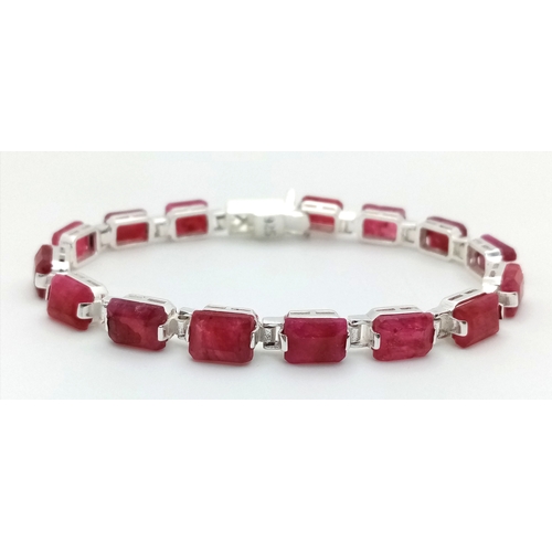 766 - An Emerald Cut Ruby Gemstone Tennis Bracelet. Set in 925 Silver. 17cm. CD-1937