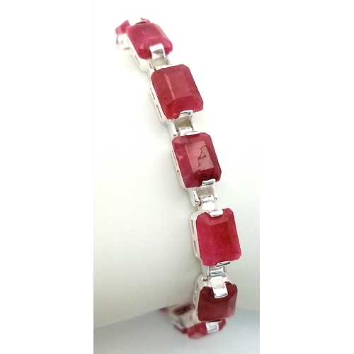 766 - An Emerald Cut Ruby Gemstone Tennis Bracelet. Set in 925 Silver. 17cm. CD-1937