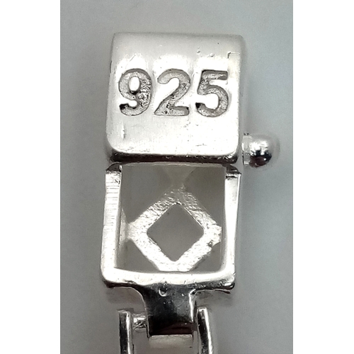 766 - An Emerald Cut Ruby Gemstone Tennis Bracelet. Set in 925 Silver. 17cm. CD-1937