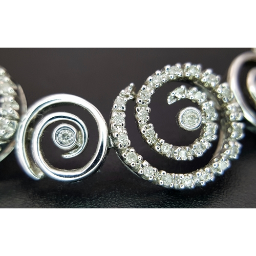 128 - A 14K White Gold Diamond Swirl Tennis Bracelet. c 1.5ctw of round brilliant cut diamonds in a swirl ... 
