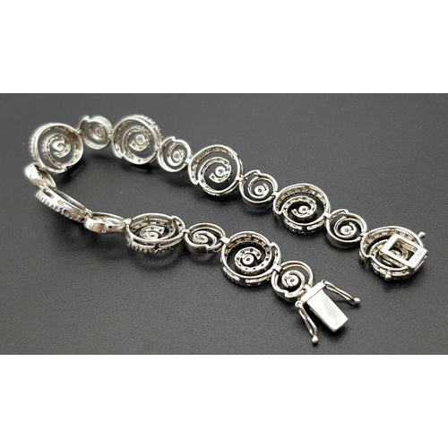 128 - A 14K White Gold Diamond Swirl Tennis Bracelet. c 1.5ctw of round brilliant cut diamonds in a swirl ... 