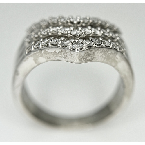 180 - AN 18K WHITE GOLD FIVE ROW DIAMOND CHEVRON SHAPED RING. 0.75CTW OF ROUND AND TAPERED BAGUETTE DIAMON... 