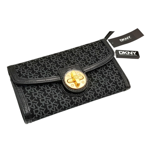 935 - A matching set of DKNY shoulder bag (34X18 cm), purse (19.5 X12 cm) and an umbrella. In very good co... 