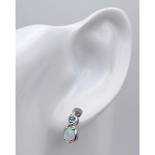579 - A Stunning Pair of 9 Carat White Gold Opal and Blue Topaz Set Stud Earrings. 1.2cm Length. Gross Com... 