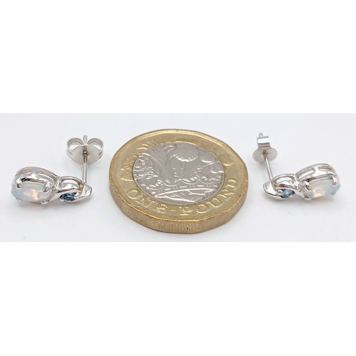 579 - A Stunning Pair of 9 Carat White Gold Opal and Blue Topaz Set Stud Earrings. 1.2cm Length. Gross Com... 