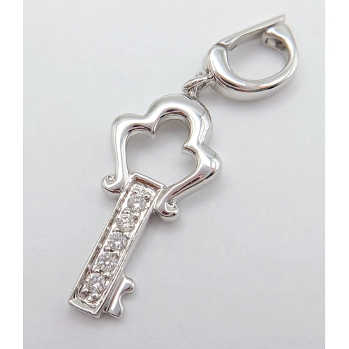 580 - AN 18K WHITE GOLD DIAMOND SET KEY CHARM / PENDANT. TOTAL WEIGHT 1.3G. SC 9060