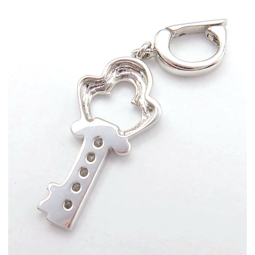 580 - AN 18K WHITE GOLD DIAMOND SET KEY CHARM / PENDANT. TOTAL WEIGHT 1.3G. SC 9060