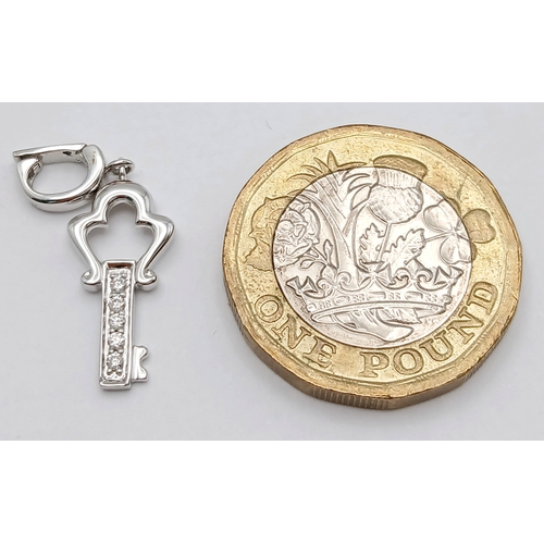 580 - AN 18K WHITE GOLD DIAMOND SET KEY CHARM / PENDANT. TOTAL WEIGHT 1.3G. SC 9060