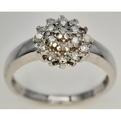 593 - A 9K WHITE GOLD DIAMOND CLUSTER RING. DIAMOND WEIGHT 0.25CT. TOTAL WEIGHT 2.2G. SIZE L 1/2. SC 9083