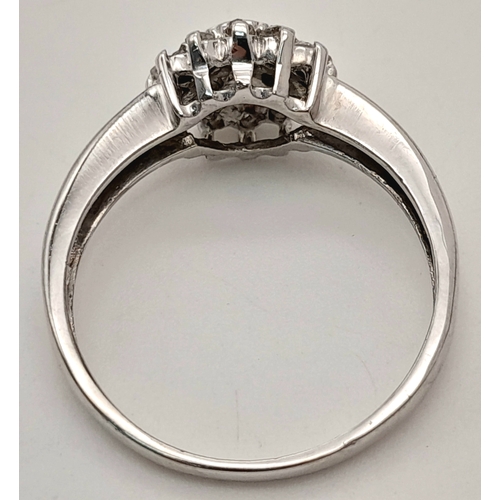 593 - A 9K WHITE GOLD DIAMOND CLUSTER RING. DIAMOND WEIGHT 0.25CT. TOTAL WEIGHT 2.2G. SIZE L 1/2. SC 9083