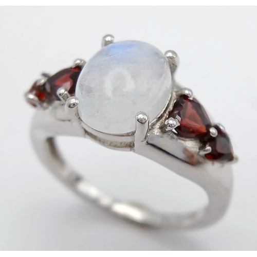 606 - A Vintage Sterling Silver Moonstone and Garnet Set Ring, Size O. The ring likely dates to around the... 