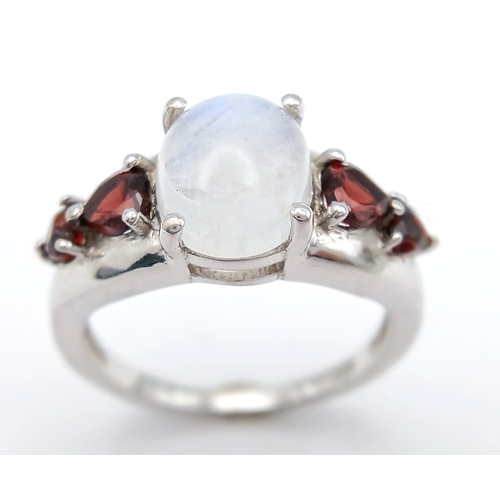 606 - A Vintage Sterling Silver Moonstone and Garnet Set Ring, Size O. The ring likely dates to around the... 