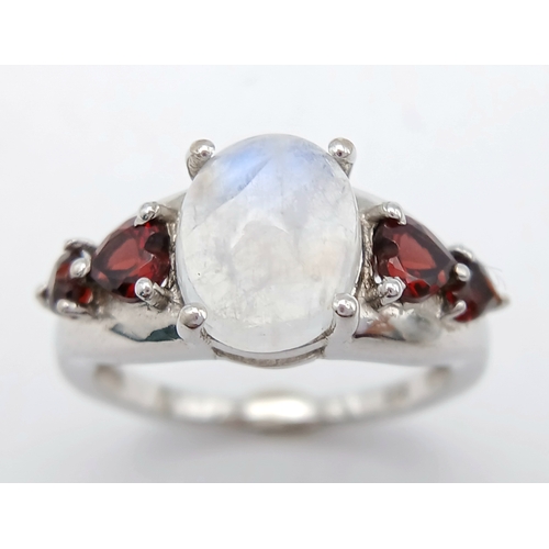 606 - A Vintage Sterling Silver Moonstone and Garnet Set Ring, Size O. The ring likely dates to around the... 
