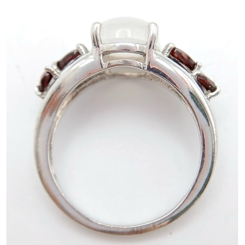 606 - A Vintage Sterling Silver Moonstone and Garnet Set Ring, Size O. The ring likely dates to around the... 