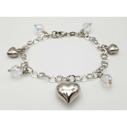 979 - A STERLING SILVER CRYSTAL AND HEARTS CHARM BRACELET. 9.6G. JSIL-9002