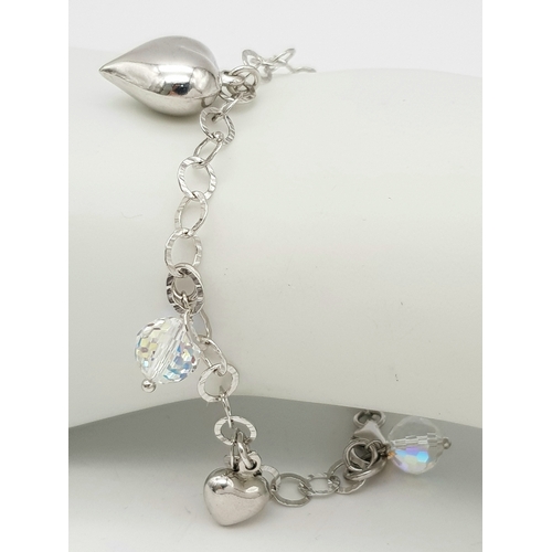 979 - A STERLING SILVER CRYSTAL AND HEARTS CHARM BRACELET. 9.6G. JSIL-9002