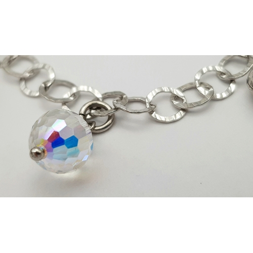 979 - A STERLING SILVER CRYSTAL AND HEARTS CHARM BRACELET. 9.6G. JSIL-9002