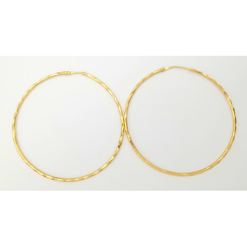 165 - A PAIR OF LARGE HOOP EARRINGS IN 18K GOLD .   6.8gms