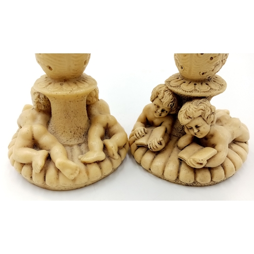 779 - A Pair of Antique Ivorine Candlesticks with Ornate Cherub Decoration. 22cm tall.