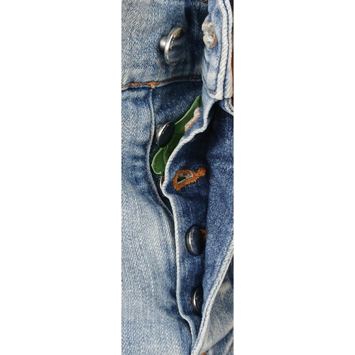 959 - A pair of Amiri light wash distressed skinny jeans featuring heavy ripped details throughout the leg... 