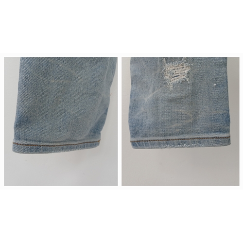959 - A pair of Amiri light wash distressed skinny jeans featuring heavy ripped details throughout the leg... 