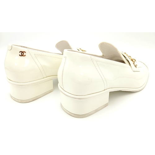 594 - A pair of Chanel White Patent Leather Chain Loafers. Gold-tone CC charm and chain detail across the ... 