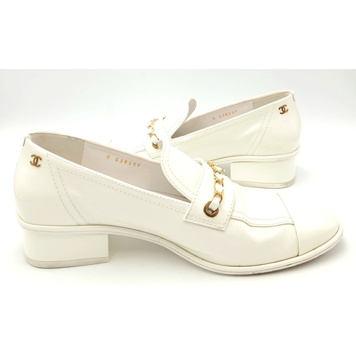 594 - A pair of Chanel White Patent Leather Chain Loafers. Gold-tone CC charm and chain detail across the ... 